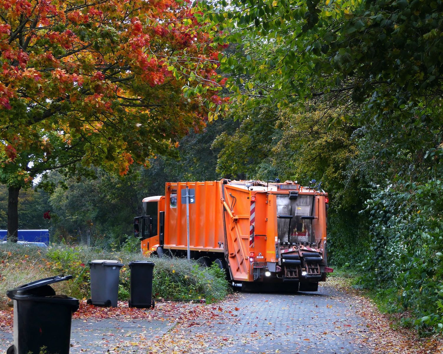 a garbage truck is parked on the side of the road